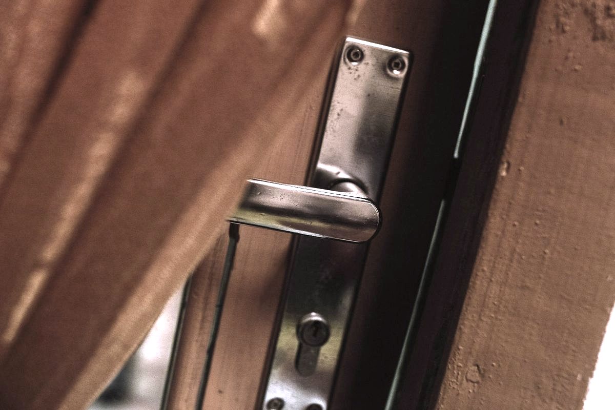 Continuous Hinges Installation — Door handle and latch hardware being checked on a wooden door