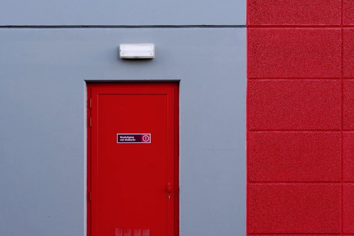 Panic Bars & Exit Devices — Porte de sortie de secours rouge équipée d'une barre antipanique